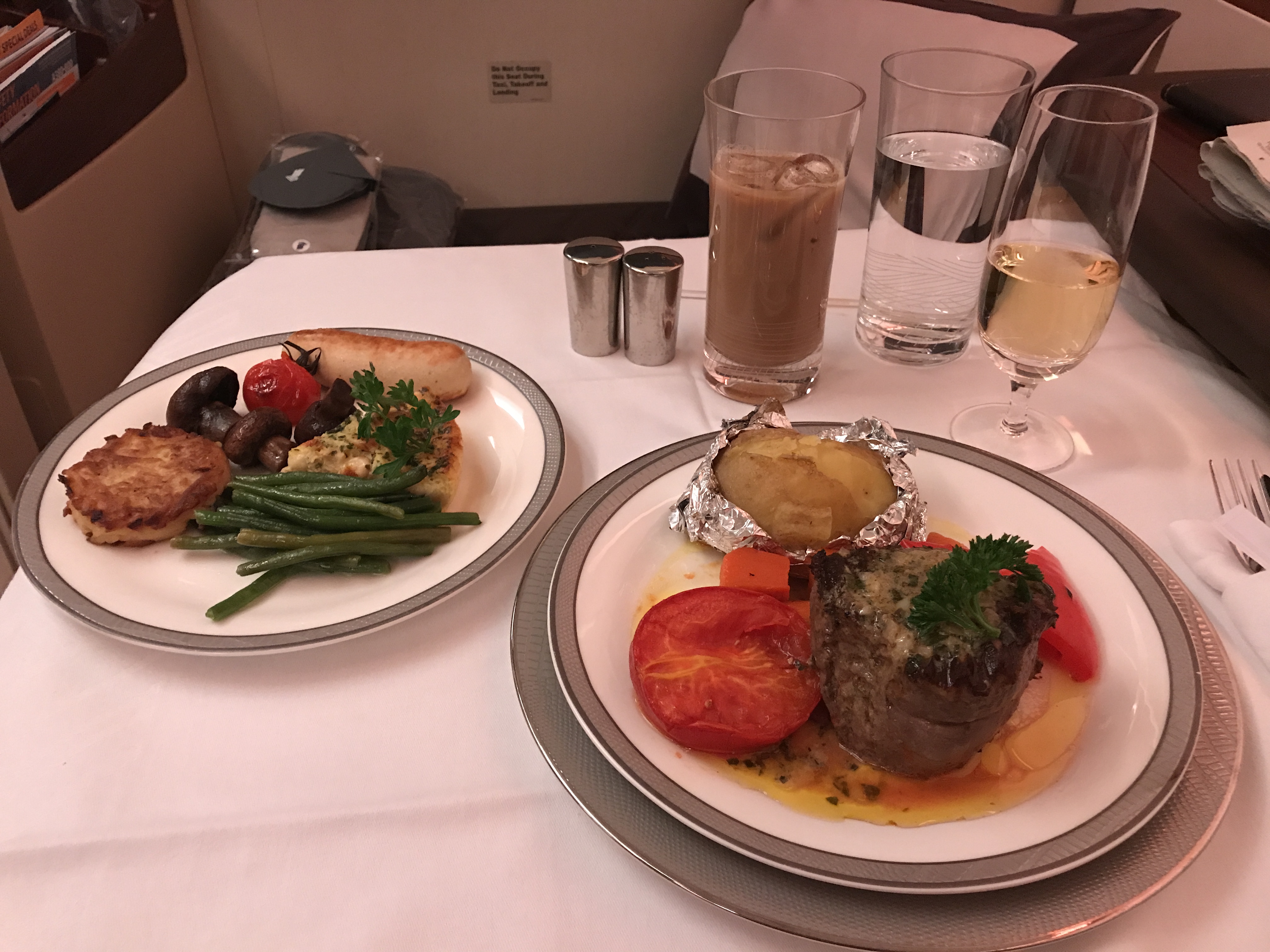 At left: goat cheese quiche with green beans, rosti potatoes, mushrooms, and veal sausage. At right: Steak with a baked potato.